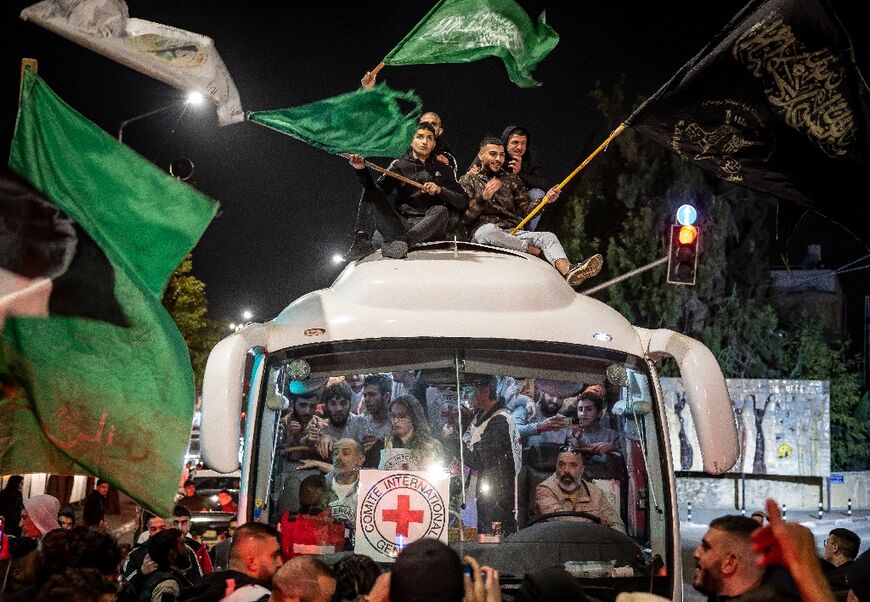 A crowd surrounds a Red Cross bus carrying Palestinian prisoners released from Israeli jails in exchange for hostages released by Hamas from the Gaza Strip, in Ramallah in the occupied West Bank