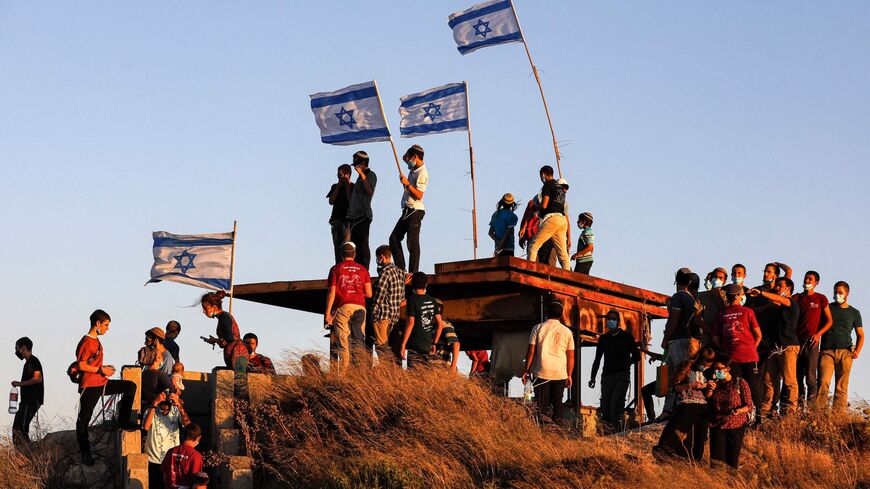 Israeli settlers gather on a hill next to the Palestinian town of Halhul, north of Hebron in the occupied West Bank on June 30, 2020, as they attend a rally against US President Donald Trump's peace plan which might create a Palestinian state and also the Israeli annexation of some parts West Bank.