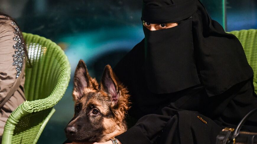 A woman sits with her German shepherd at the Barking Lot cafe in Saudi Arabia.
