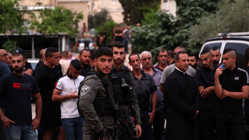 Israeli security forces and onlookers gather in front of a car wash, where five Arab Israelis were shot dead, in the village of Yafia, west of Nazareth, on June 8, 2023.