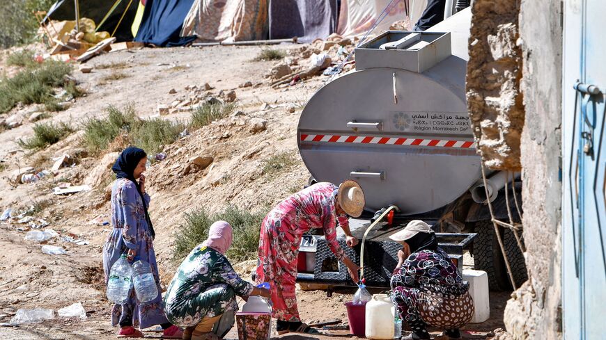 Survivors fill up water from a tanker truck in their earthquake-hit village of Ineghede on September 17, 2023. Over a week since a 6.8-magnitude quake devastated parts of central Morocco, many worry that the dire living conditions and poor hygiene spell new threats for the survivors. The disaster killed nearly 3,000 people and injured thousands more when it hit in Al-Haouz province. (Photo by FETHI BELAID / AFP) (Photo by FETHI BELAID/AFP via Getty Images)