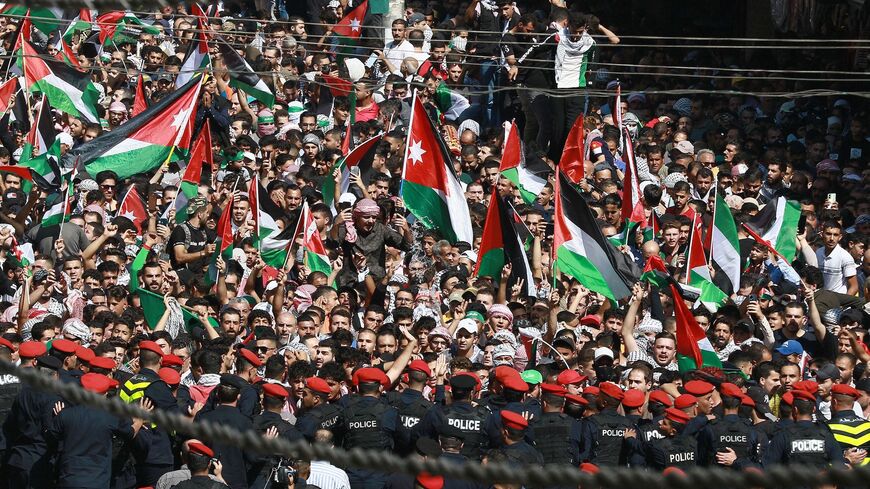 Demonstrators wave Palestinian and Jordanian flags during a demonstration in Amman in support of Palestinians amid Israeli airstrikes on Gaza in response to the surprise attack by Hamas against it, October 13, 2023. 