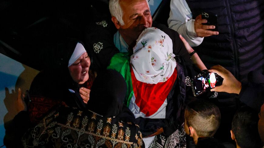 Friends and relatives of Palestinian prisoners that were released from the Israeli Ofer military facility in exchange for hostages freed by Hamas in Gaza, react as they are paraded in Baytunia in the occupied West Bank on November 24, 2023. After 48 days of gunfire and bombardment that claimed thousands of lives, the first hostages to be released under a truce deal between Israel and Hamas were handed over on November 24, both sides said, nearly seven weeks after they were seized. (Photo by Jaafar ASHTIYEH 