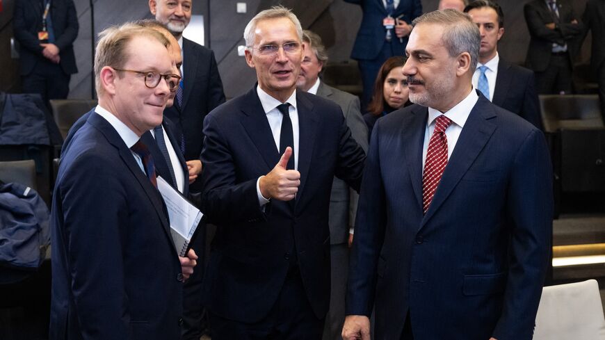 NATO Secretary General Jens Stoltenberg (C) speaks with Turkish Foreign Minister Hakan Fidan (R) and Swedish Foreign Minister Tobias Billstrom (L).