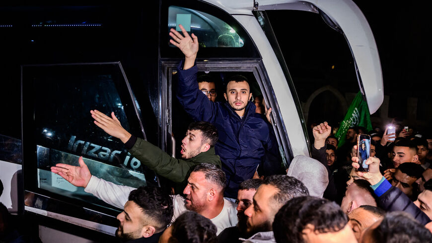A newly released prisoner waves from a bus during a welcome ceremony following the release of Palestinian prisoners from Israeli jails in exchange for Israeli hostages held in Gaza by Hamas since the October 7 attacks, in Ramallah in the occupied West Bank early on November 30, 2023. 