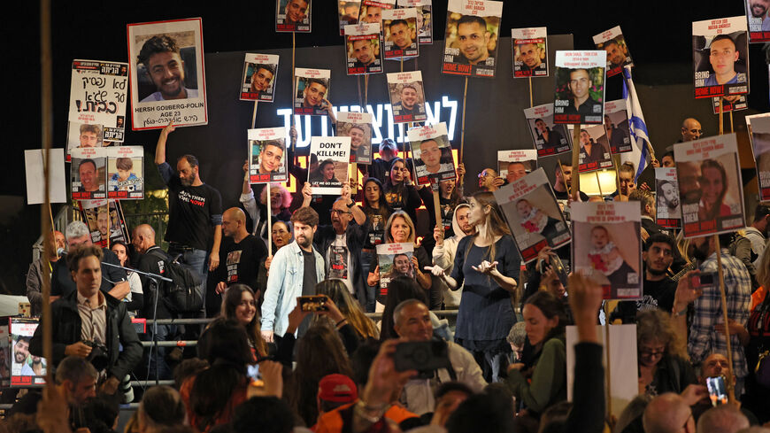 Protesters lift placards and portraits during a demonstration in Tel Aviv on December 2, 2023, calling for the release of Israeli hostages held in Gaza since the October 7 attacks. Israel and Hamas brushed off international calls to renew an expired truce on December 2 as air strikes pounded militant targets in Gaza and Palestinian groups launched volleys of rockets.